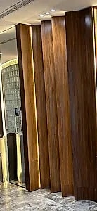 Fluted walnut panelling in raking light.