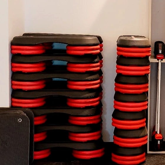 Stacked red and black bumper plates in the functional training store.