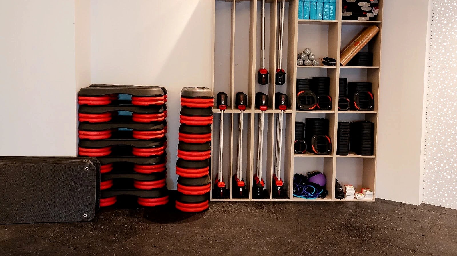 The functional training store: stacked bumper plates, kettlebells, medicine balls and mats in open shelving.