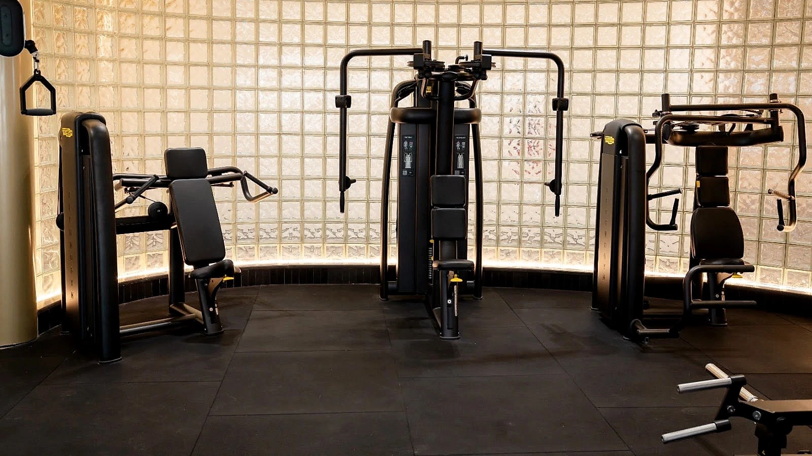 Selectorised machines set against a curved, textured wall on the training floor.