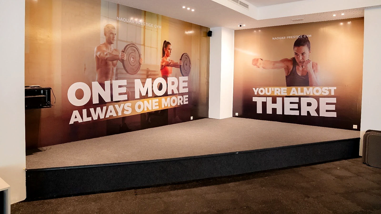 The studio floor and its raised platform, in front of a wall printed with the club's motto.